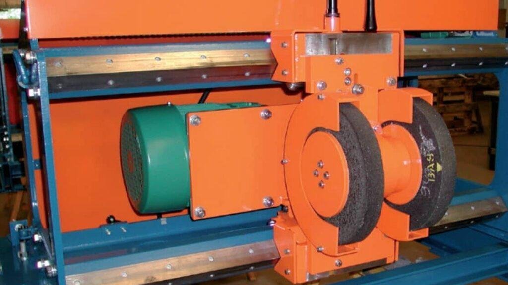 Grinding machine for an industrial crusher roller